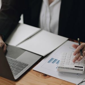 Consult financial concept. Businesswoman pointing at calculator Consult financial concept. Businesswoman pointing at calculator and using laptop computer.